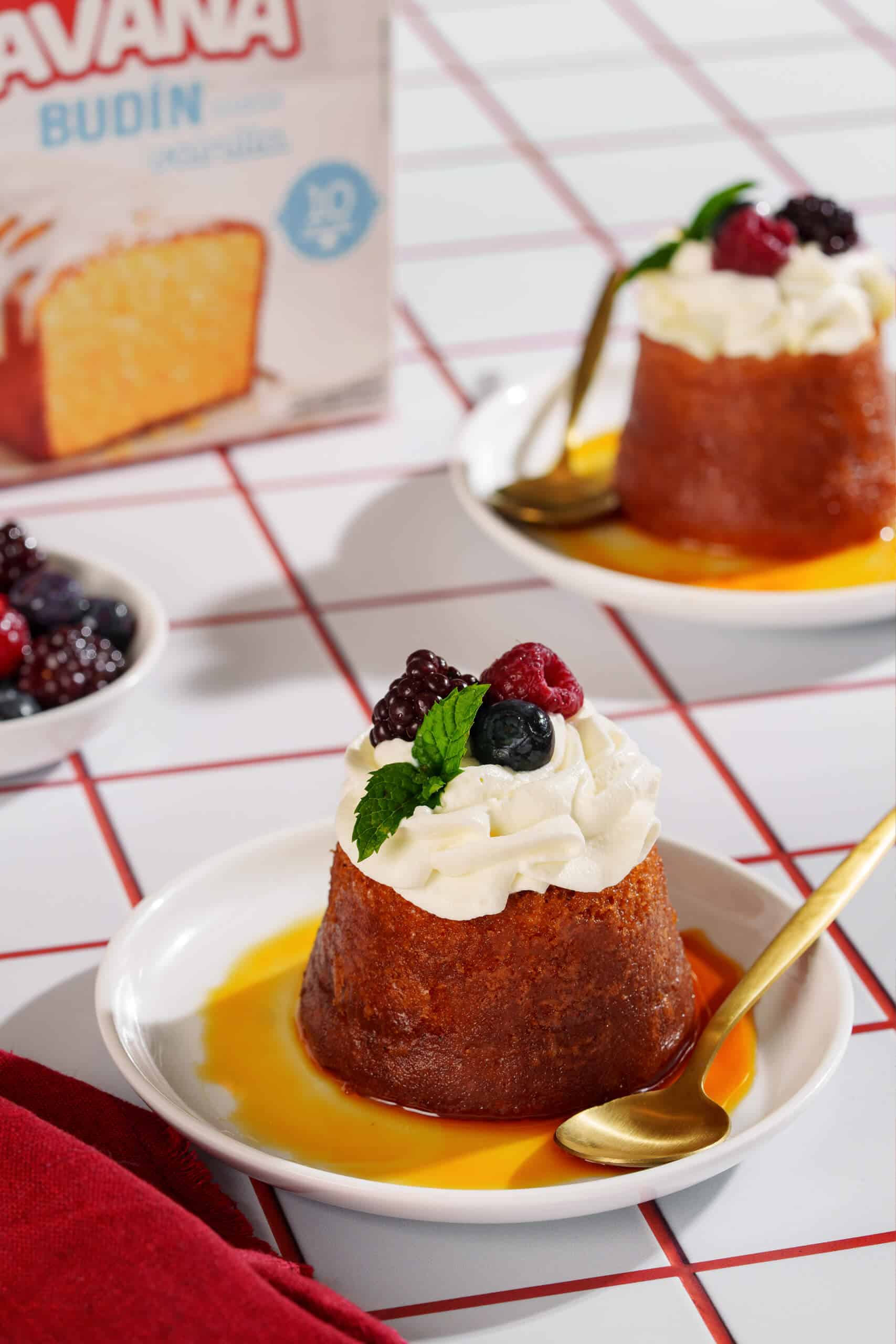Bizcochos borrachos con frutas, crema y salsa de caramelo en plato blanco.