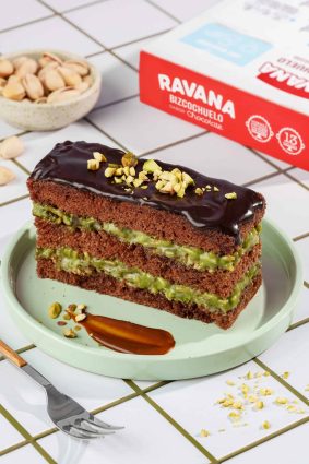 Tarta de chocolate y pistacho con cobertura de ganache y pistachos picados.