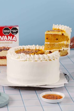Torta de coco y maracuyá con crema y decoraciones de azúcar.